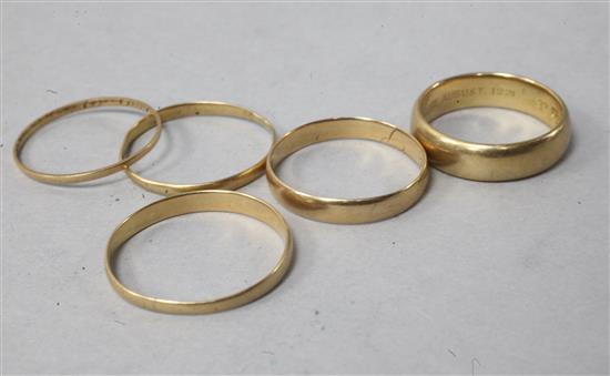 Two 18ct wedding bands and three other bands.